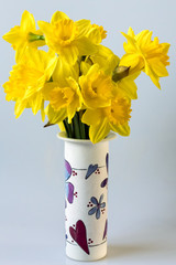 A bunch of of golden Daffodils in a decorated ceramic vase