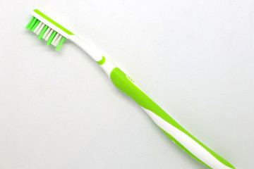 White and green toothbrush on a white background