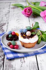 Easter cupcake topped with multicolored marzipan eggs, chocolate nest and marshmallow cream