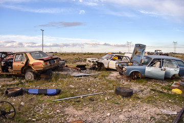 Old damaged cars in the junkyard. Car graveyard.