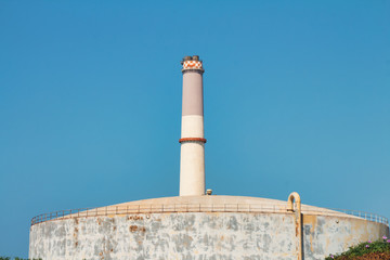 The chimney of the Tel Aviv Reading power plant near a large natural gas storage tank