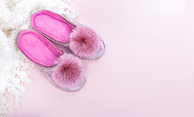 Pink home velvet slippers and white plaid on a pink background.