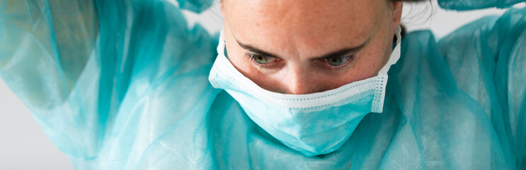 Woman doctor wearing protection face mask against coronavirus. Banner panorama medical staff...
