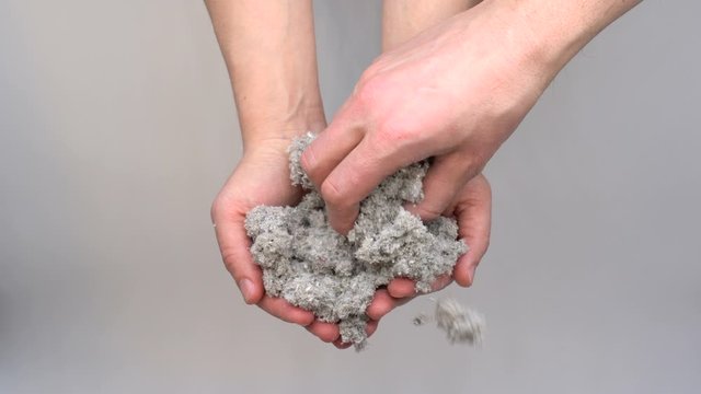 Hands holding eco-friendly cellulose insulation for walls for floors recycled newsprint warm house heat preservation and energy saving