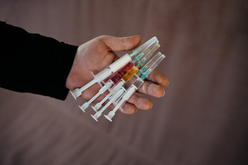 vaccinations against infections and viruses. syringes in hand. selective focus, film and grain photo
