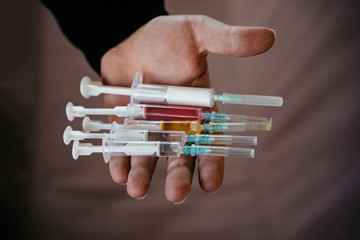 vaccinations against infections and viruses. syringes in hand. selective focus, film and grain photo