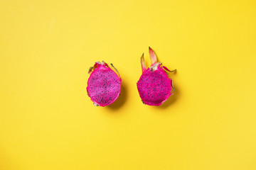 Pink pitahaya or dragon fruit on yellow background. Top view. Copy space. Creative design banner. Summer time. Tropical travel, exotic fruit. Vegan and vegetarian concept