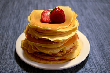 stack of pancakes with maple syrup and fruits
