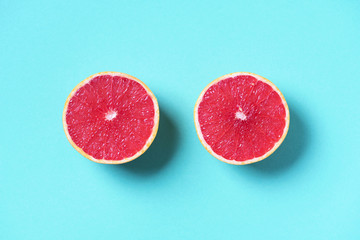 Fresh red grapefruit on blue background. Top view. COpy space. Creative design banner. Tropical travel, exotic fruit. Vegan and vegetarian food. Summer time