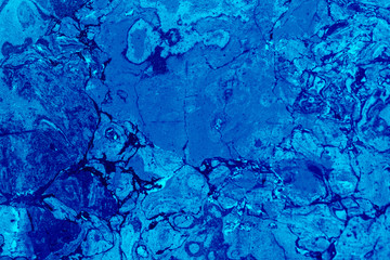 Abstract textured tinted classic blue color surface texture rough background, cement concrete floor or wall. The image is tinted in the color of the 2020 year-classic blue.