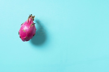 Pink pitahaya or dragon fruit on blue background. Top view. Copy space. Creative design banner....