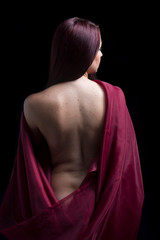 Portrait of woman with bare back on black background