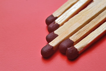 several matches on a red background. macro shot.