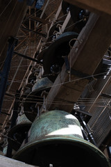 Rustic bells hanging inside old bell tower in Bruges.