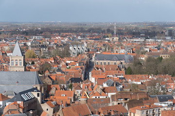 Naklejka na ściany i meble Bruges panorama from the top of the bell tower, red roofs, trees and quiet streets below.
