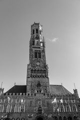 Brugge Belfry tower facade full of flagues of famous tourist destination at Grote markt square in Bruges