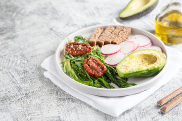 nutritious breakfast. wild garlic, sun-dried tomatoes, whole grain bread, avocado, seeds. good nutrition concept