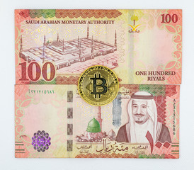 Saudi Arabian 100 Riyal bank note with Bitcoin crypto currency