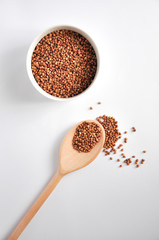 buckwheat on a plate and spoon isolated background