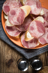 Sandwich made of wheat bread, butter and slices of dry-cured sausage.