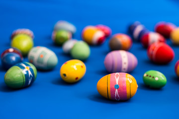 multicolored wooden eggs on blue background