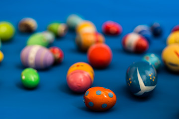 multicolored wooden eggs on blue background
