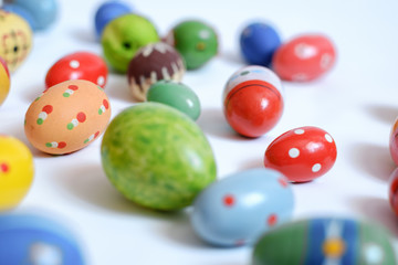 multicolored wooden eggs on white background