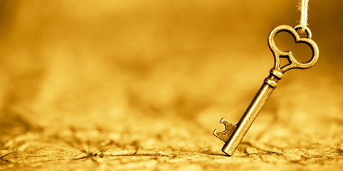 Antique solution key, web banner on gold background. Life coaching, success concept. Copy space.
