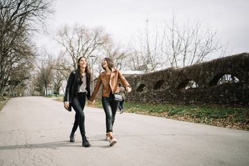 Two happy girls walking on the street