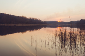 Obraz premium Beautiful colorful sunset over a forest lake
