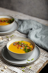 Pumpkin puree soup with seeds and greens