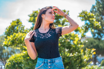 Street style, a brunette enjoying the sun in a black lace t-shirt