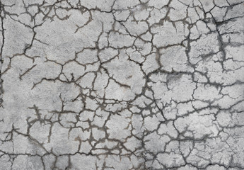 A gray concrete wall with curly cracks that show moisture. Background
