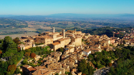 Fototapeta na wymiar Village of Montepulciano with wonderful architecture and houses. A beautiful old town in Tuscany, Italy. Perfect for travels and vacations - aerial view with a drone