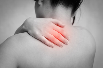 the woman massages the shoulder with her hand. the view from the back. isolated on white background