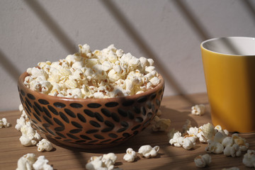 popcorn in a wooden bowl on table at early morning 
