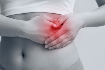 the woman holds her hands behind her belly. the sore spot is highlighted in red. concept