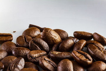 Macro of coffee beans in a white coffee cup