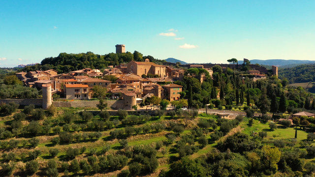 An Italian village with green meadows all over the village. Aerial view with a drone of the beautiful and old village of Monticchiello in Tuscany, Italy	