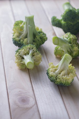 green healthy broccoli on light wood