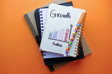 Close up of growth chart on notepad on orange background 