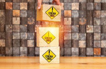 woman  hand placing piece of a big cube with Road sign indicating coronavirus 