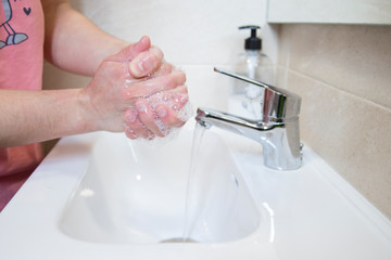 Woman washing her hands with soap.