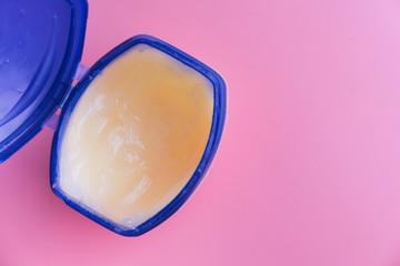 a container with cream oil petroleum jelly.