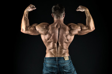 Fototapeta na wymiar Grow strong. Bodybuilder flex arms back view. Sports coach black background. Sportsman show biceps triceps. Taking sports to stay in shape. Physical training and sports. Sports gym or club