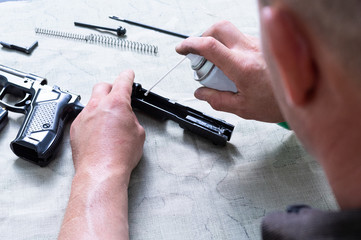 A man lubricates a gun. A man is cleaning a gun. Oil for weapons.