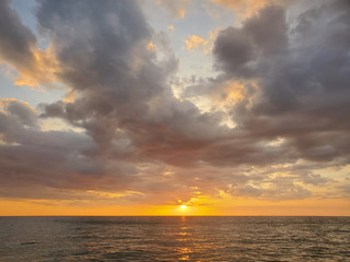 Abstract seascape panoramic background - Orange color in the sky, sunset late afternoon. Calm seas/ocean in the bottom of the frame. Minimalistic simple background image, blue and yellow colors.