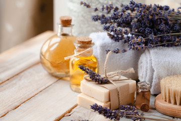 Concept of natural organic oil in cosmetology for moisturizing skin care and aromatherapy. Handmade soap forgentle body treatment. Wooden background, lavender flower. Copy space for text, closeup