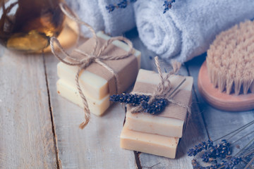 Concept of natural organic oil in cosmetology for moisturizing skin care and aromatherapy. Handmade soap forgentle body treatment. Wooden background, lavender flower. Copy space for text, closeup