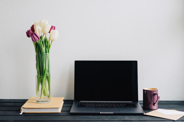 A cozy workplace. Laptop, bouquet of beautiful flowers.